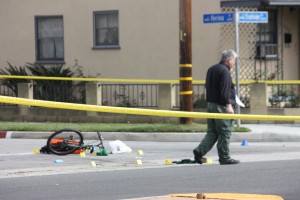 An investigator from the Los Angeles County Sheriff’s Department Homicide Division inspects the murder scene looking for clue at Studebaker Road and Farina Street in Norwalk on Tuesday afternoon. Brian Hews Photo