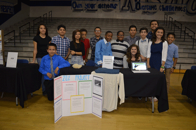 Students in Mayfair Middle School's award-winning civics program stand before a display about their 20 percent project, in which they create programs to benefit the community. The school was recently honored with one of three 2015 Awards of Excellence for its civics program.