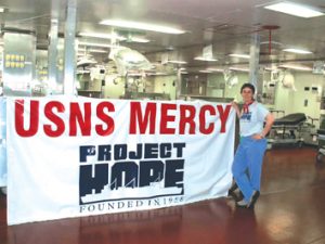Carole Snyder, a US Army  veteran, a RN, and PIH Health's Program Manager of Emergency Preparedness, onboard the USNS Mercy. Snyder travelled on the Mercy to Sumatra after the earthquake, helping-injured patients, and providing humanitarian care.