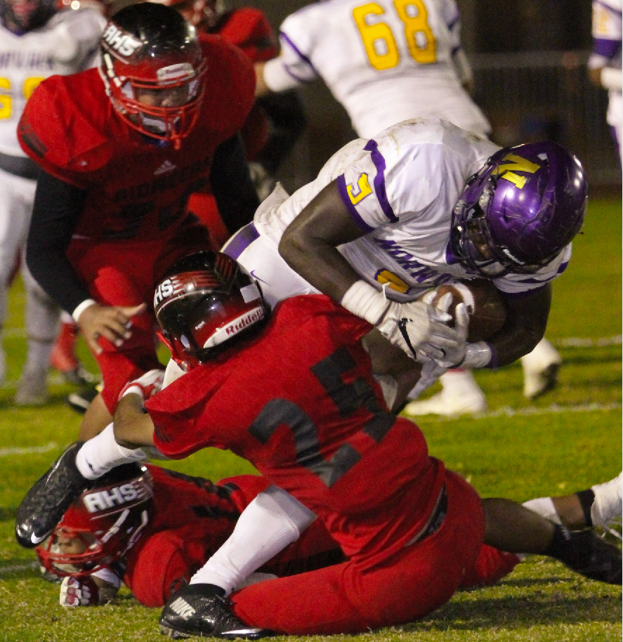 Photo caption: Artesia senior cornerback Andres Covarrubias makes a tackle on Norwalk senior running back Jordan Thomas in last Friday night's Suburban League game. Thomas led the Lancers with 125 yards and one rushing touchdown. Norwalk won 40-28 to clinch at least a share of third place.